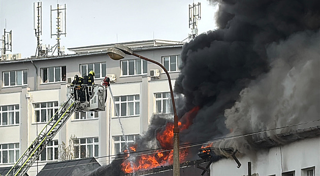 Na Žižkově hoří ubytovna, část střechy se propadla. Nevětrejte, vyzývá starosta